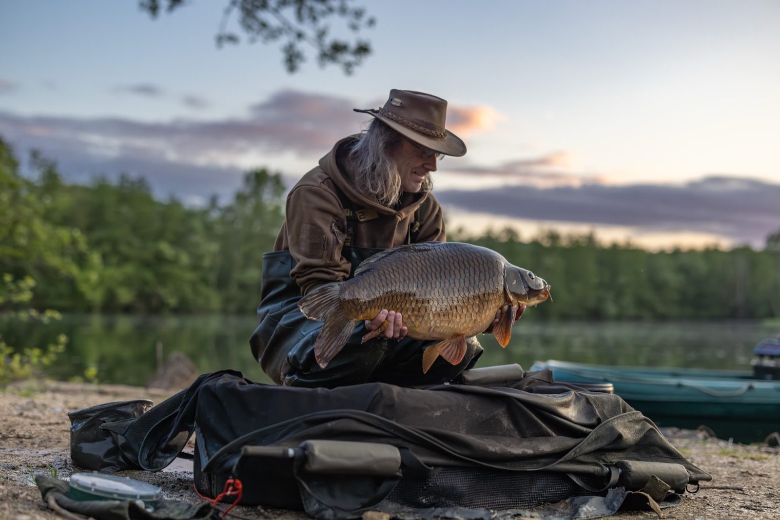 Angler holding a mirror carp in golden light
